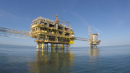 Offshore engineers on a platform handle equipment during cement replacement in an Albian reservoir off Albania's coast.